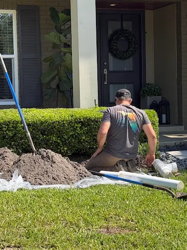 Plumber replacing a main water line in a front yard