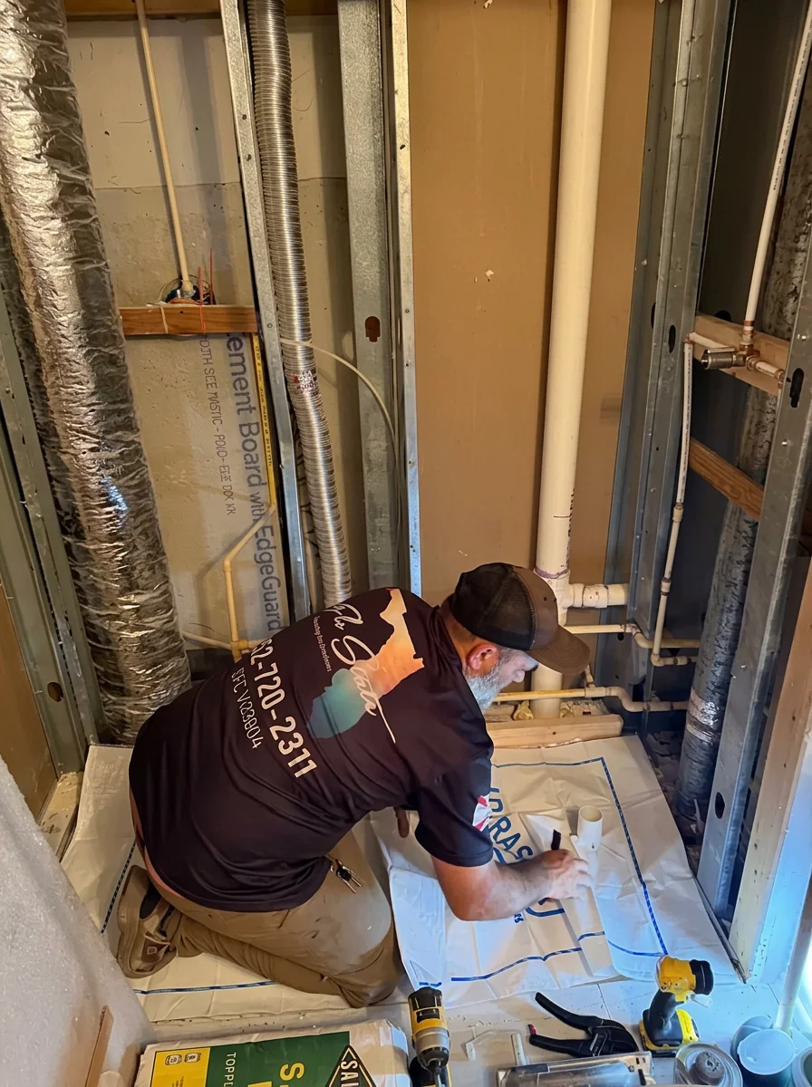 Plumber running new supply lines inside a framed wall